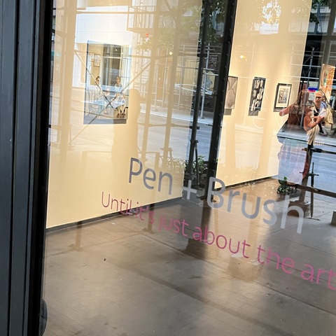 Dana Ellyn in the window at Pen + Brush gallery in NYC wtih her painting Gender Neutral Family
